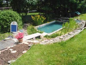 a small swimming pool in a yard with grass at Penzion U dvojice in Nové Město na Moravě