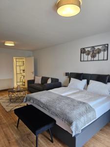 a bedroom with a large bed and a couch at Hotel Fuchs & Hase SELF CHECK IN in Rosegg