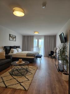 a living room with a bed and a couch and a table at Hotel Fuchs & Hase SELF CHECK IN in Rosegg