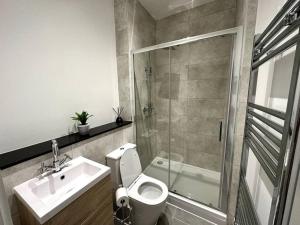 een badkamer met een toilet, een wastafel en een douche bij Spacious and Elegant Apartment in Birmingham