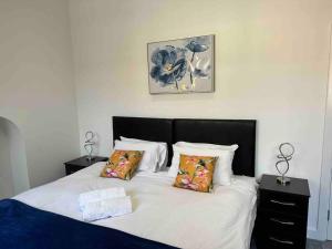 een slaapkamer met een wit bed met 2 kussens bij Spacious and Elegant Apartment in Birmingham