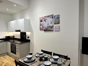 een keuken met een tafel met borden erop bij Spacious and Elegant Apartment in Birmingham