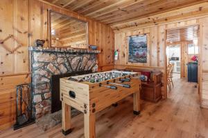 a wooden room with a chess table in front of a stone fireplace at Boulder Bay Lakefront Getaway - Across the street from the lake and Boulder Bay Park! in Big Bear Lake