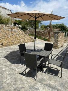 a table and chairs with an umbrella on a patio at Modern & Cozy Studio in Koroni