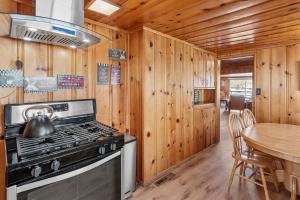 a kitchen with a stove and a dining table at Boulder Bay Lakefront Getaway - Across the street from the lake and Boulder Bay Park! in Big Bear Lake