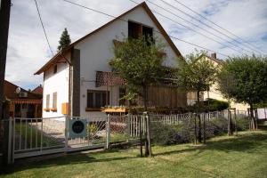 une maison blanche avec une clôture devant elle dans l'établissement Simply House, à Balatonboglár