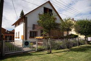 a white house with a fence in front of it at Simply House in Balatonboglár