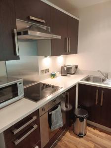 a kitchen with a sink and a microwave at A Home in the City. in Sheffield