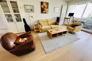 sala de estar con 2 sillas y mesa en Stylish and Bright Apartment on the Outskirts of Bordeaux, en Burdeos