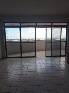 Habitación vacía con puertas de cristal y suelo de baldosa. en Cantinho para mulheres, en Parnaíba