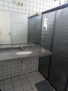 uma casa de banho com um lavatório e um espelho em Cantinho para mulheres na Parnaíba