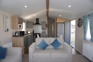 a living room with a couch and a kitchen at Tattershall Lakes getaway in Tattershall