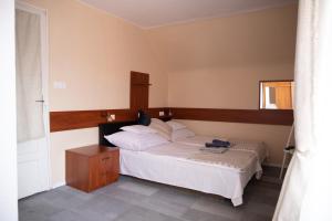 a bedroom with a white bed and a wooden headboard at Simply House in Balatonboglár