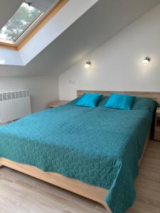 ウケンチンにあるApartament Pod Żaglemのベッドルーム(青い枕の大型ベッド1台付)