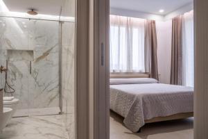 1 dormitorio con 1 cama y ducha acristalada en L'OLEANDRO Room's - Suite & Spa da Giuseppe en Gonnosfanàdiga