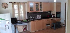 een keuken met houten kasten en een witte koelkast bij ARTEMIS in Svoronata