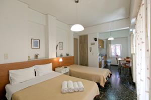 um quarto de hotel com duas camas e uma sala de jantar em Selana Apartments em Mytilini