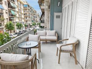 een balkon met stoelen en tafels en een straat bij Victroria Grand Palace Apartment in Athene