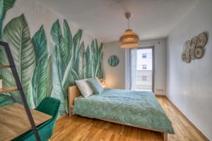 ein Schlafzimmer mit einem Bett und einem Wandbild aus Blättern in der Unterkunft COSY FLAT direct access Genève-Airport-Palexpo in Annemasse