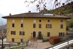 a yellow house with a hill in the background at RAINBOW in Rovereto