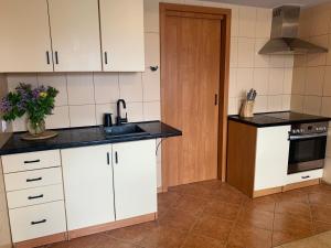 a kitchen with white cabinets and a sink at VillaAnita in Augustów