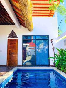 a house with a swimming pool in front of a building at Villa Ocean in Puerto Escondido
