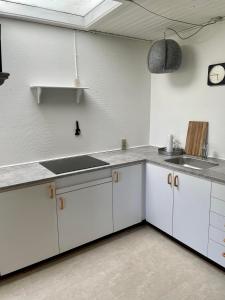 a kitchen with white cabinets and a sink at Bui Hotel Humble in Humble