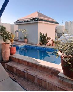 a swimming pool in a house with potted plants at Riad D'or meknes in Meknès
