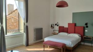 - une chambre avec un grand lit et une tête de lit rouge dans l'établissement Ottantotto Viterbo, à Viterbe