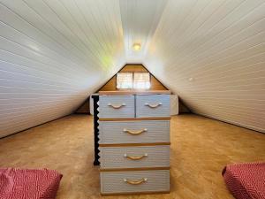 a tiny house with a bed and a dresser in it at moorea temae bungalow lory bord de mer in Moorea