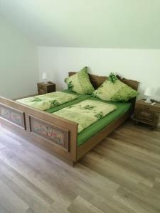 een bed met groene lakens en kussens in een kamer bij Ferienwohnung in Kaning in Kaning