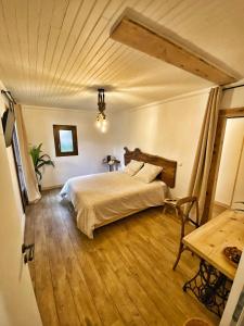 Schlafzimmer mit einem Bett und Holzboden in der Unterkunft U PASTURELLU in Pioggiola