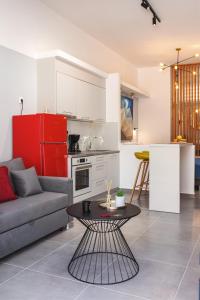 uma cozinha e uma sala de estar com um sofá e uma mesa em Theo's Cozy Apartment near Athens airport em Spata