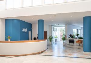 an office lobby with blue columns and a reception desk at Azul Eco Hotel in Skaleta