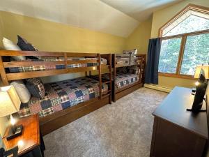 a room with two bunk beds and a desk at New Property! Updated 3 bed 3 bath condo with mountain ski slope views in Bretton Woods in Bretton Woods