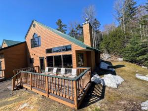 uma casa com um grande deque no quintal em New Property! Updated 3 bed 3 bath condo with mountain ski slope views in Bretton Woods em Bretton Woods