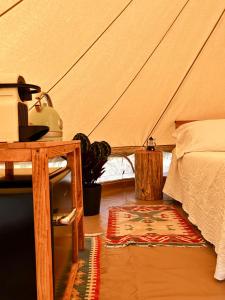 a bedroom with a tent with a bed and a rug at Stecadó Glamping in Dolceacqua