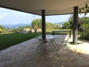 eine Terrasse mit einem Tisch und Stühlen unter einem Pavillon in der Unterkunft Haus am Hügel 