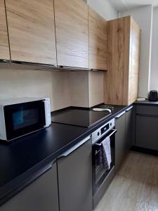 uma cozinha com um micro-ondas e uma bancada preta em JAD - Luxury - 3 Room Apartments - Urban Plaza em Brasov