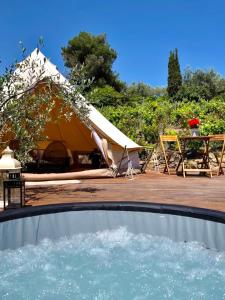 a tent with a table and a pool of water at Stecadó Glamping in Dolceacqua