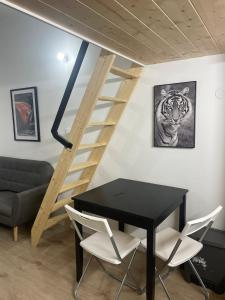 een kamer met een zwarte tafel en stoelen en een trap bij Le petit Louis Fort - Studio cosy-Gratte Ciel in Villeurbanne