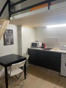 een kleine keuken met een tafel en een magnetron bij Le petit Louis Fort - Studio cosy-Gratte Ciel in Villeurbanne