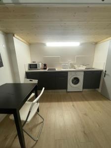 een keuken met een tafel en een wasmachine bij Le petit Louis Fort - Studio cosy-Gratte Ciel in Villeurbanne