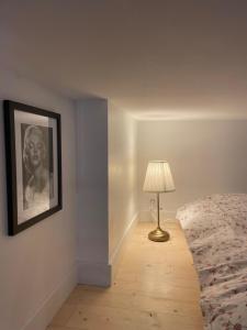 een slaapkamer met een bed met een lamp en een foto bij Le petit Louis Fort - Studio cosy-Gratte Ciel in Villeurbanne