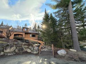 una casa con una escalera de madera frente a una casa en FC43 Renovated cozy spacious cottage with AC, air hockey, wifi close to ski trails!, en Bretton Woods