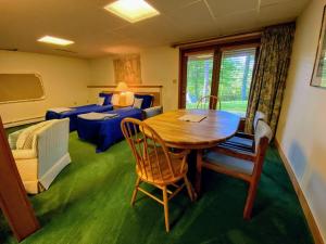 a room with a table and chairs and a bedroom at FC20 Comfortable Forest Cottage home - AC, great for kids, lots of yard space! Walk to the slopes! in Bretton Woods