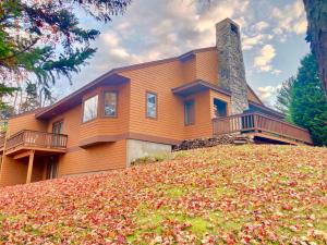 una casa en la cima de una colina con hojas en el suelo en FC20 Comfortable Forest Cottage home - AC, great for kids, lots of yard space! Walk to the slopes!, en Bretton Woods