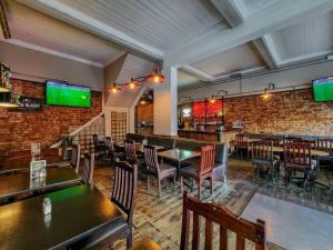 ein Restaurant mit Tischen und Stühlen und eine Bar in der Unterkunft Exquisite and Homely Apartment, Private Balcony in Kapstadt