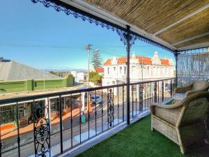 uma varanda com 2 cadeiras e vista para uma rua em Exquisite and Homely Apartment, Private Balcony em Cidade do Cabo