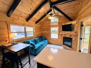 a living room with a blue couch and a fireplace at BMV8 Tiny Home village near Bretton Woods in Twin Mountain